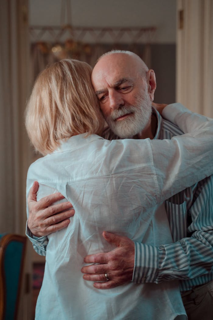 An elderly couple shares a warm embrace, symbolizing love and companionship.